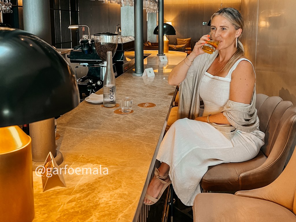 mulher sentada no bar tomando drink